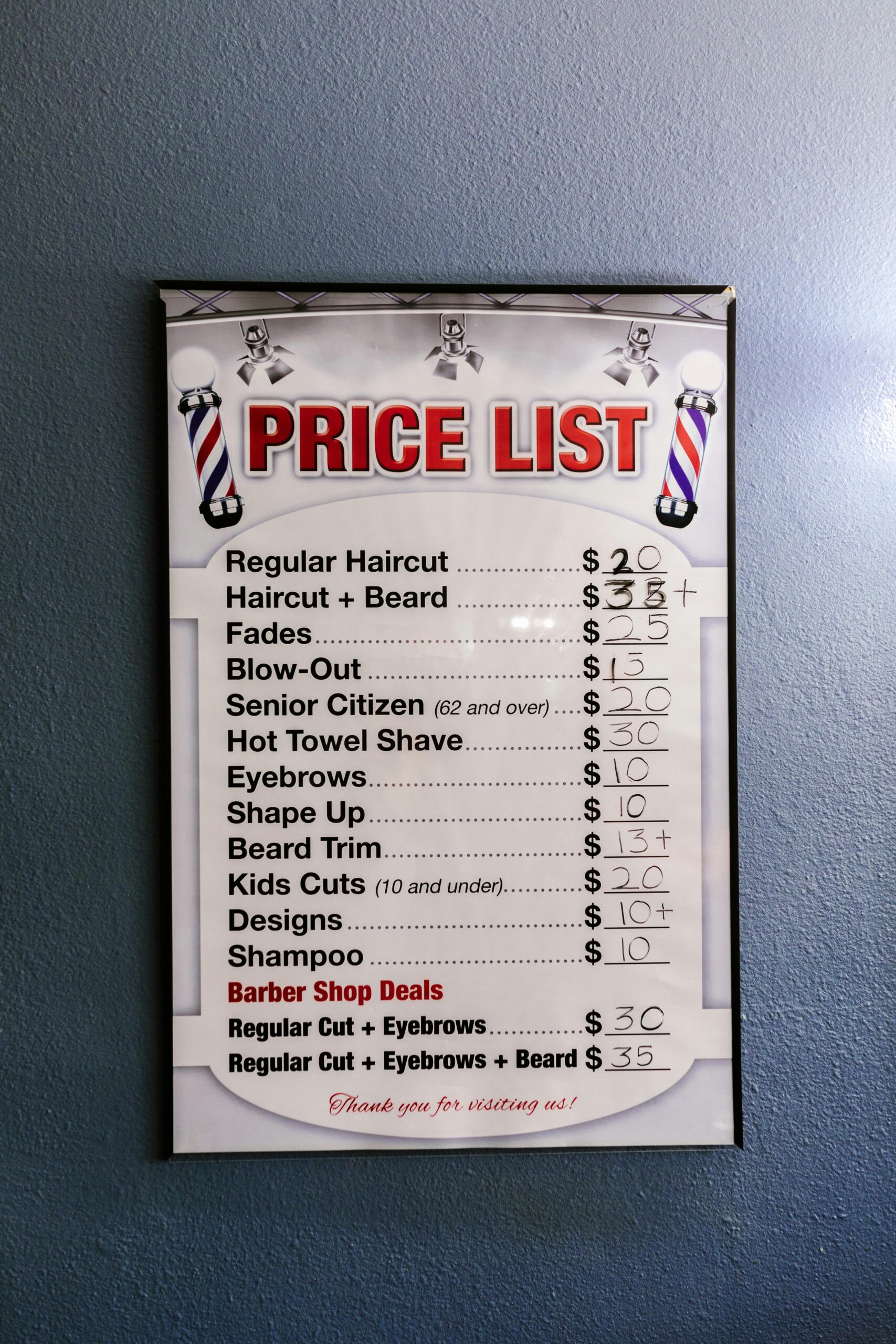 Barbershop price list featuring various haircut services on a vertical display.